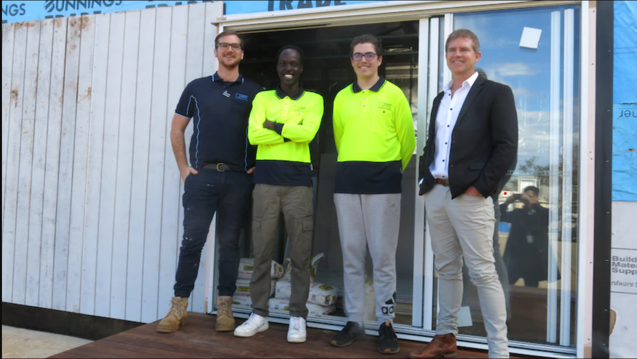 Project Supervisor Jake Bremner, trainee Yol Mareng, Jett Callaghin, and CEO Kris McCue in front of the tiny house being built. (ABC Southern Qld: David Chen)